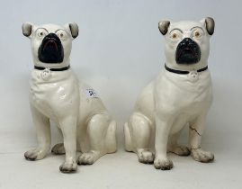 A pair of pottery pugs, 28 cm high (2) some restortation