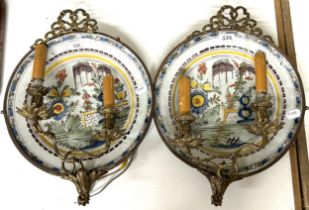 A pair of Delft polychrome plates, decorated garden scenes, made into a pair of wall sconces with