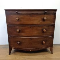 A mahogany bow front chest, having a brushing slide above three drawers, 93 cm wide