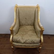 A French gilt armchair, with a padded back, arms and seat, on turned and reeded legs