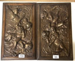 A pair of brass plaques, decorated cherubs, in oak frames, 40 x 26 cm