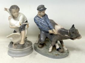 A Royal Copenhagen figure of a young boy struggling with a cow, and a young boy with two geese, 20
