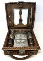 A late 19th/early 20th century whicker picnic basket, contents to include two plates, two forks, a