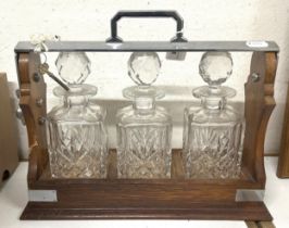 An oak and silver plated tantalus, 38 cm wide