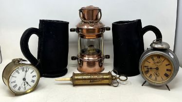 Two modern leather mugs, a brass and copper lantern, two alarm clocks, and a brass syringe (6)