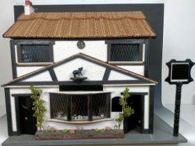 An unusual doll's house, in the form of the pub called The Pig and Whistle, in the Tudor style, with