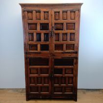 A Spanish walnut cupboard, having two pairs of panel doors with cast metal mounts, 190 cm high x