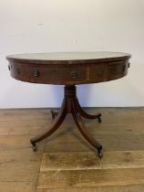 A 19th century mahogany drum table, with a tooled and gilt leather inset top, having four frieze