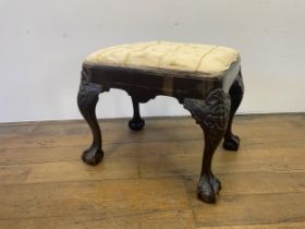 A George III style footstool, raised on carved cabriole legs to ball and claw feet, 53 cm wide