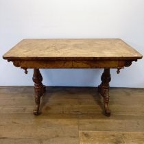 A late 19th/early 20th century walnut library table, with two frieze drawers, on carved twin end