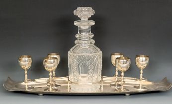 A George V silver liqueur set, comprising a fitted tray, six goblets, and a cut glass decanter,