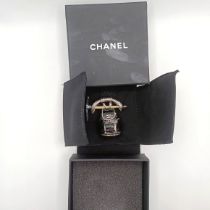 A modern Chanel brooch in the form of a rucksack with a pickaxe, boxed