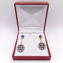 A pair of silver gilt articulated long drop earrings, set with oval cabochon sapphires, and vari-cut