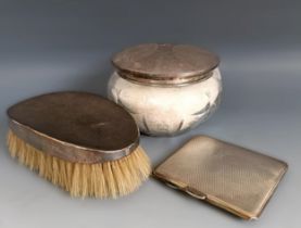 A silver cigarette case, a silver backed brush and a cut glass powder jar with a silver lid (3)
