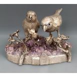 An Elizabeth II silver and purple rock crystal figure of two birds perched on a flowering sprig,