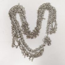 An Indian silver coloured metal belt, with attached bells