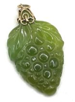 A carved green stone pendant, decorated grapes, with a yellow metal mount