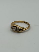 An 18ct gold and three stone diamond ring, ring size M