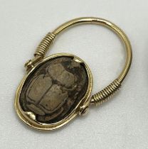 A yellow coloured metal hinged ring, inset with a scarab, the undersigned with hieroglyphics, ring
