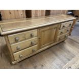 A pine dresser base, having a single cupboard door, flanked by six drawers, 88 cm wide