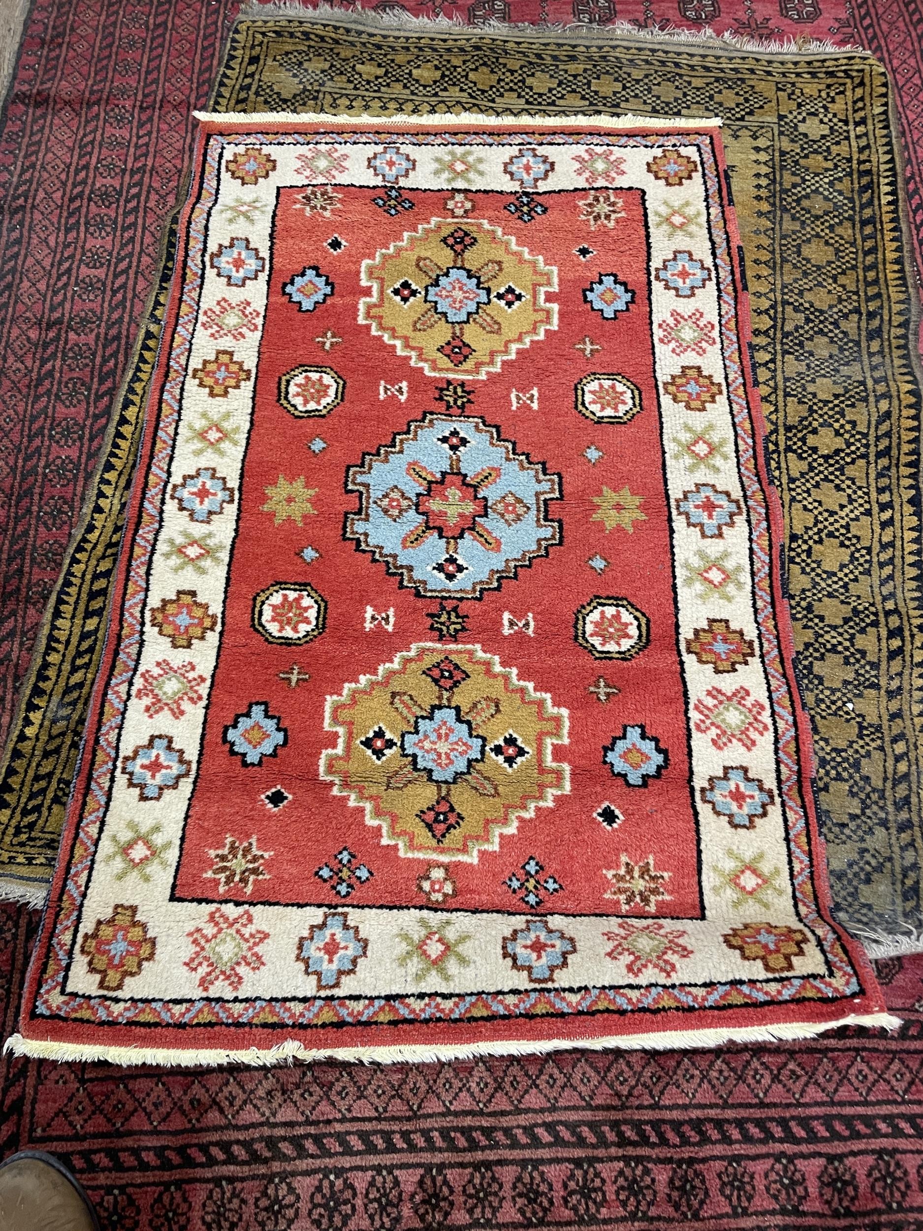 A red ground Afghan type carpet, 290 x 203 cm, a yellow ground rug, 175 x 130 cm and a red ground - Image 3 of 3