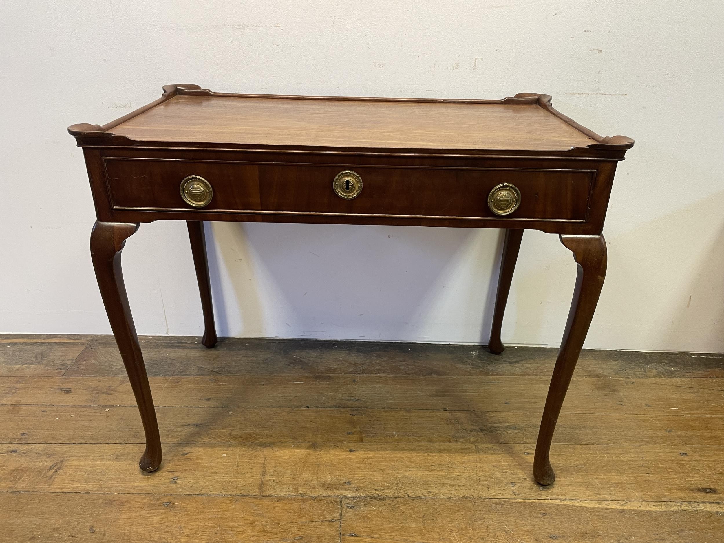 A Dutch mahogany table, having a raised rim, with a single frieze drawer on cabriole legs and pad