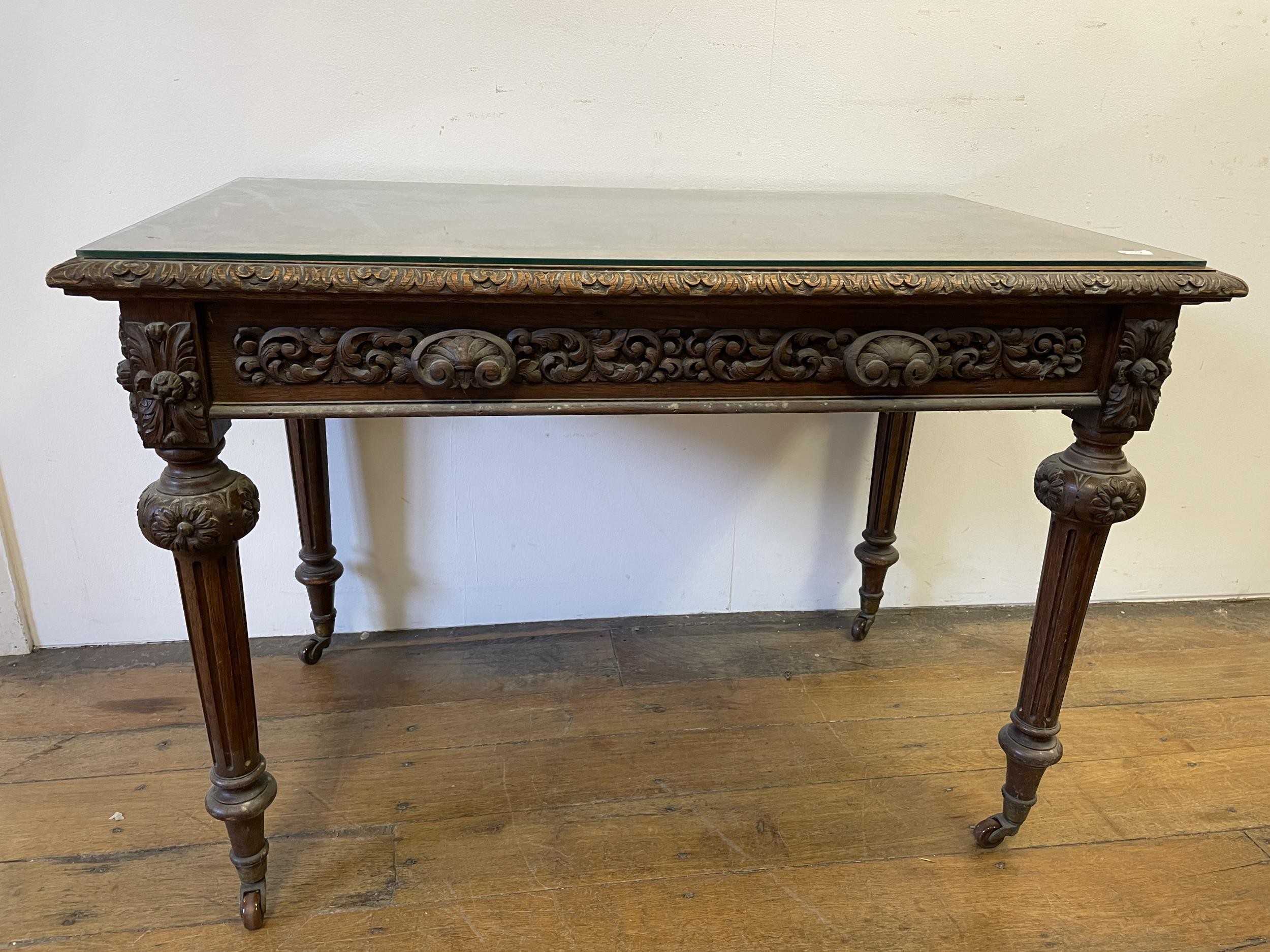 An oak writing desk, with a tooled and gilt leather top, having two drawers, on carved turned and