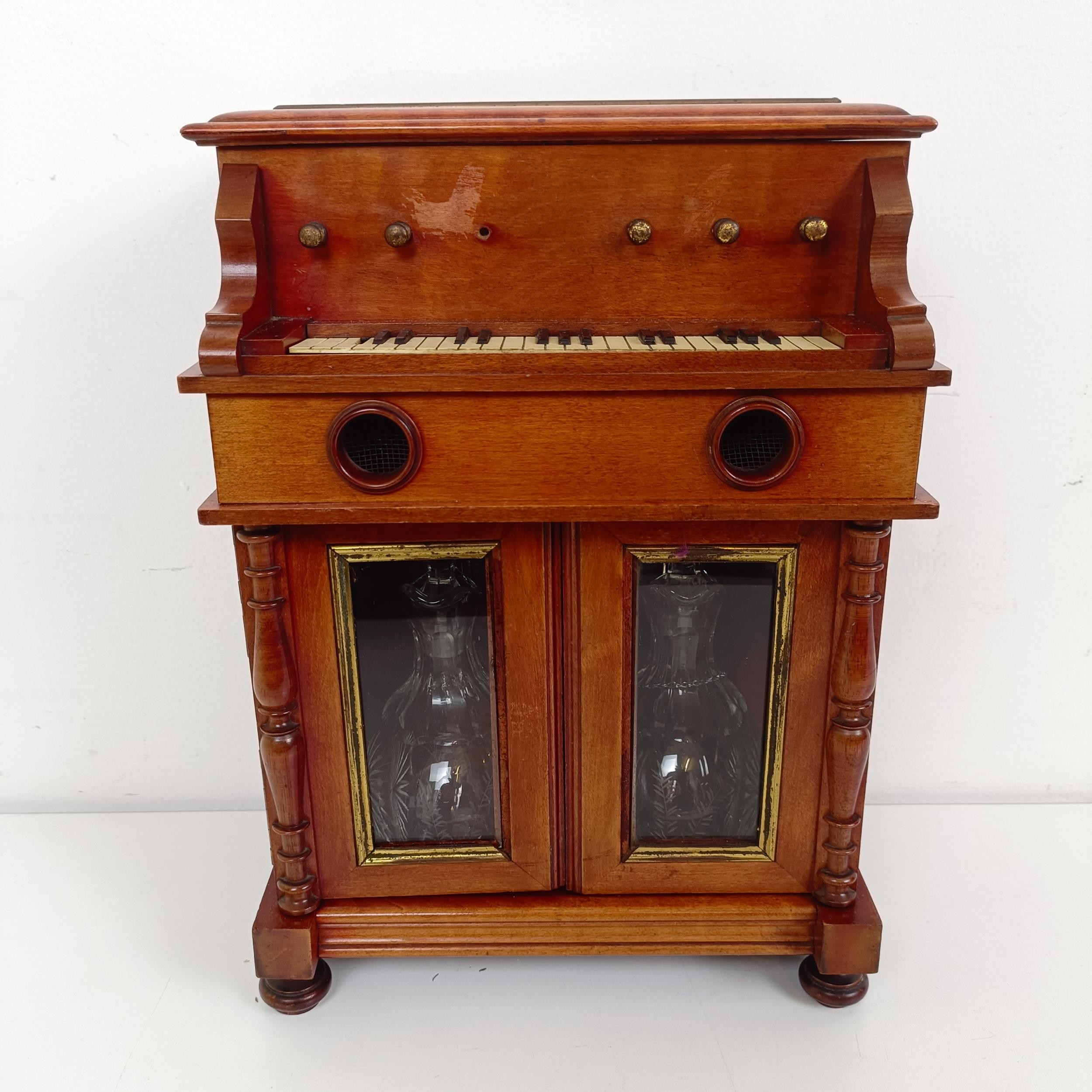 An early 20th century Continental musical tantalus/liqueur cabinet, in the form of a piano or organ,