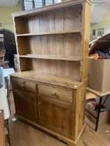 A pine dresser, the base having two drawers and two cupboard doors, 140 cm wide