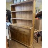 A pine dresser, the base having two drawers and two cupboard doors, 140 cm wide