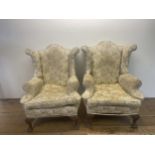 A pair of Georgian style wingback armchairs