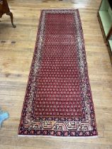 A Persian red ground rug, 322 x 107 cm