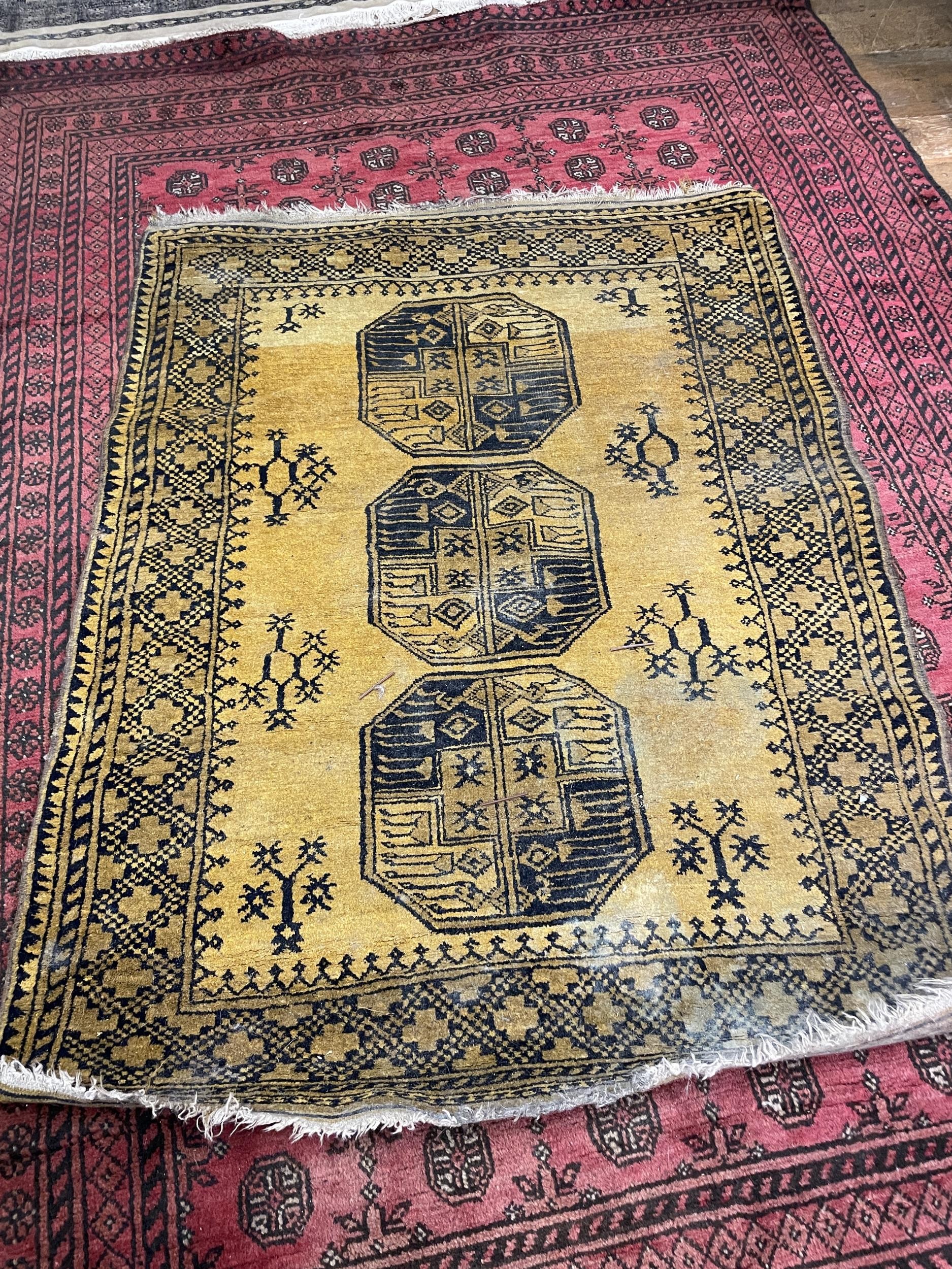 A red ground Afghan type carpet, 290 x 203 cm, a yellow ground rug, 175 x 130 cm and a red ground - Image 2 of 3