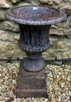 A cast iron Campana form garden urn, on a plinth base, 41 cm diameter x 70 cm high