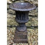 A cast iron Campana form garden urn, on a plinth base, 41 cm diameter x 70 cm high