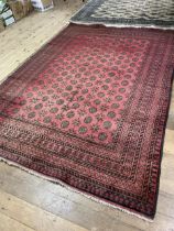 A red ground Afghan type carpet, 290 x 203 cm, a yellow ground rug, 175 x 130 cm and a red ground