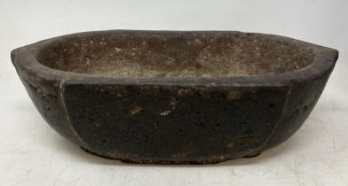 A carved stone bowl, of rounded rectangular form, 33 cm wide, and three marble spheres, approx. 10