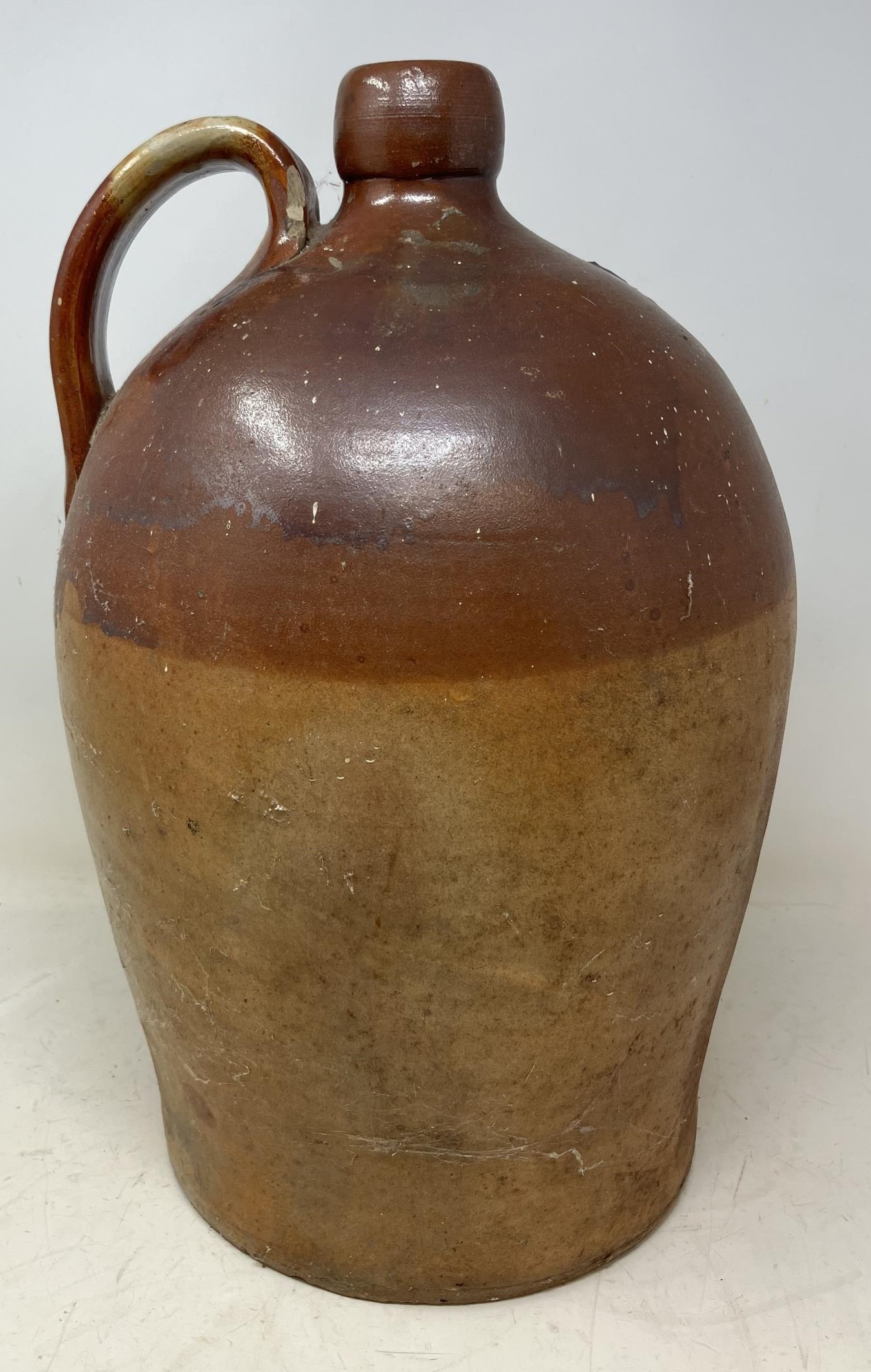 A stoneware flagon, 43 cm high, a large glass bottle, a suitcase filled with silver plated glass