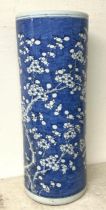 A Chinese cylindrical stick stand, decorated prunus in underglaze blue, cracked 60 cm high