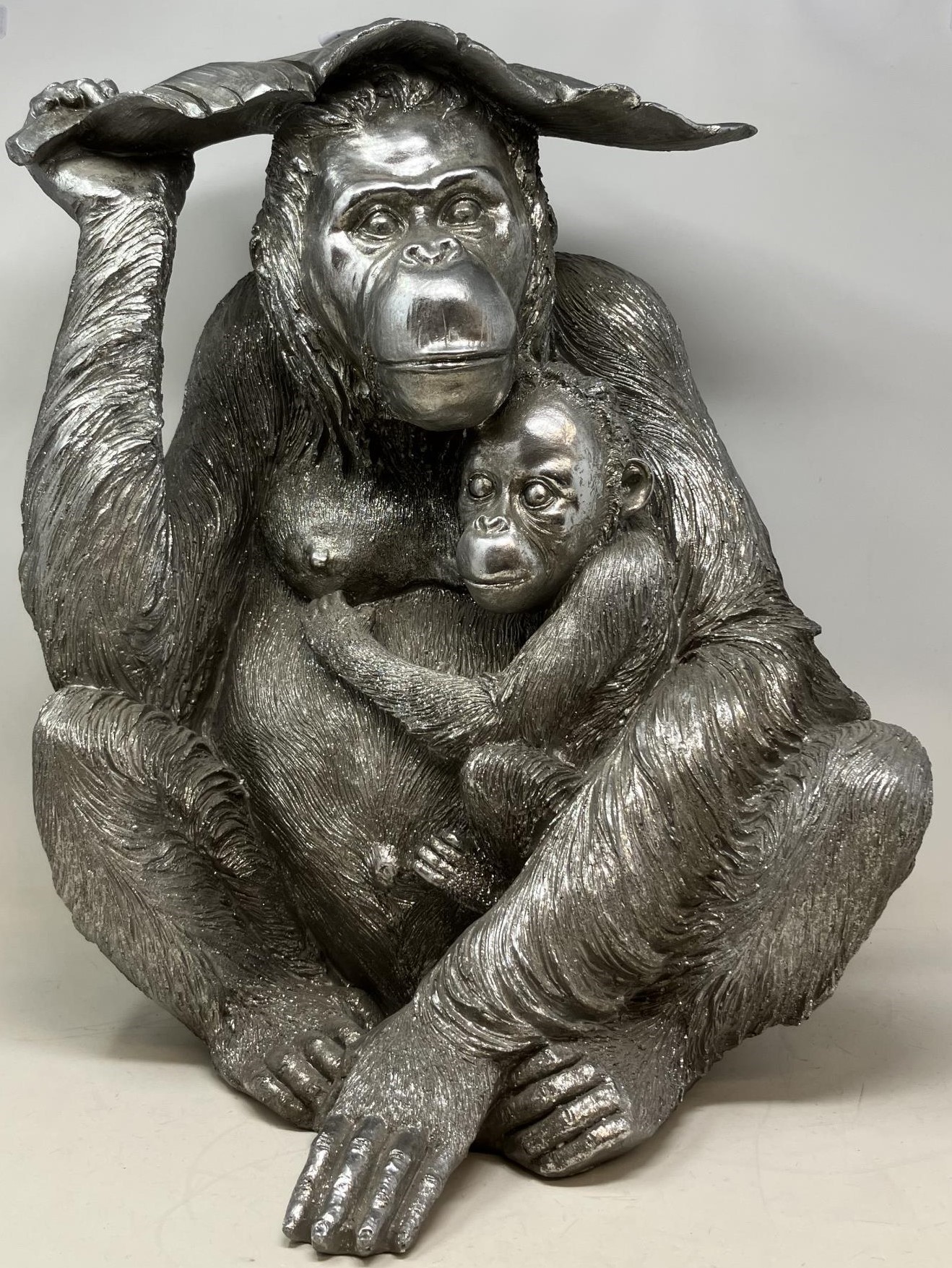 A silvered model of a orangutan, 48 cm high, and assorted blue and white balls (qty)