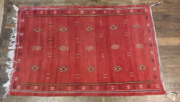 A red ground rug 193 x 132 cm