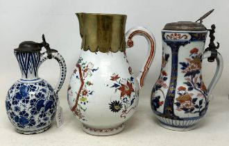 A Chinese pottery jug, with enamel decoration, 24.5 cm high, a Japanese Imari jug, with silver