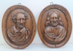 A pair of late 18th century carved oak oval panels, decorated bust portraits, 46 x 36 cm (2)