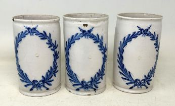 A set of three Delft pottery drug jars/cylindrical vases, decorated leaf garlands, in underglaze