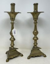 A pair of 17th century brass candlesticks, on triangular bases, 36 cm high One sconce incomplete