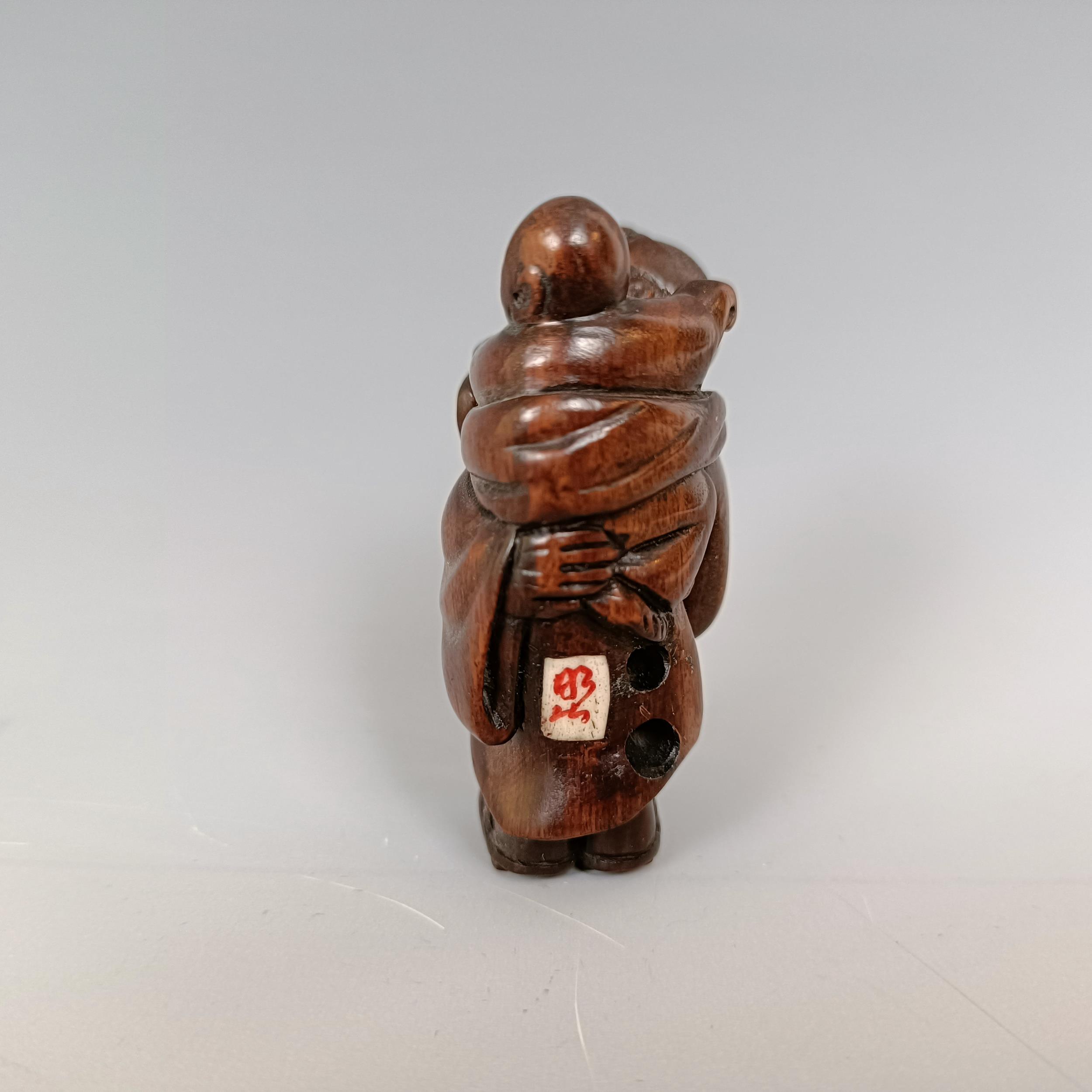 A carved wooden netsuke, in the form of mother and child, signed, 5 cm - Image 6 of 6