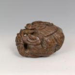 A carved wooden netsuke, in the form of a dragon, signed, 4 cm wide