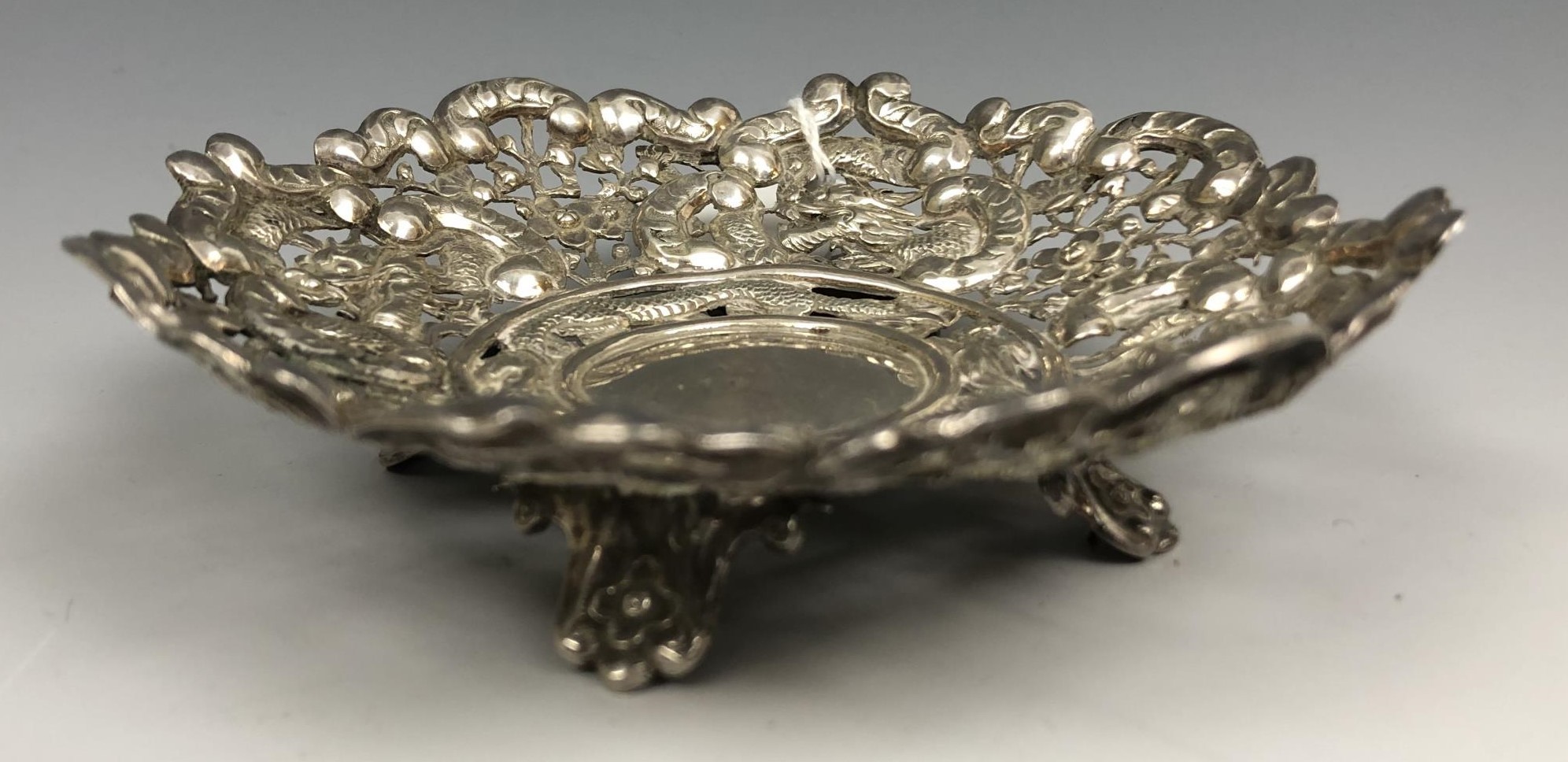 A Chinese silver coloured metal dish, embossed dragons and foliage, 12 cm diameter 2.3 ozt