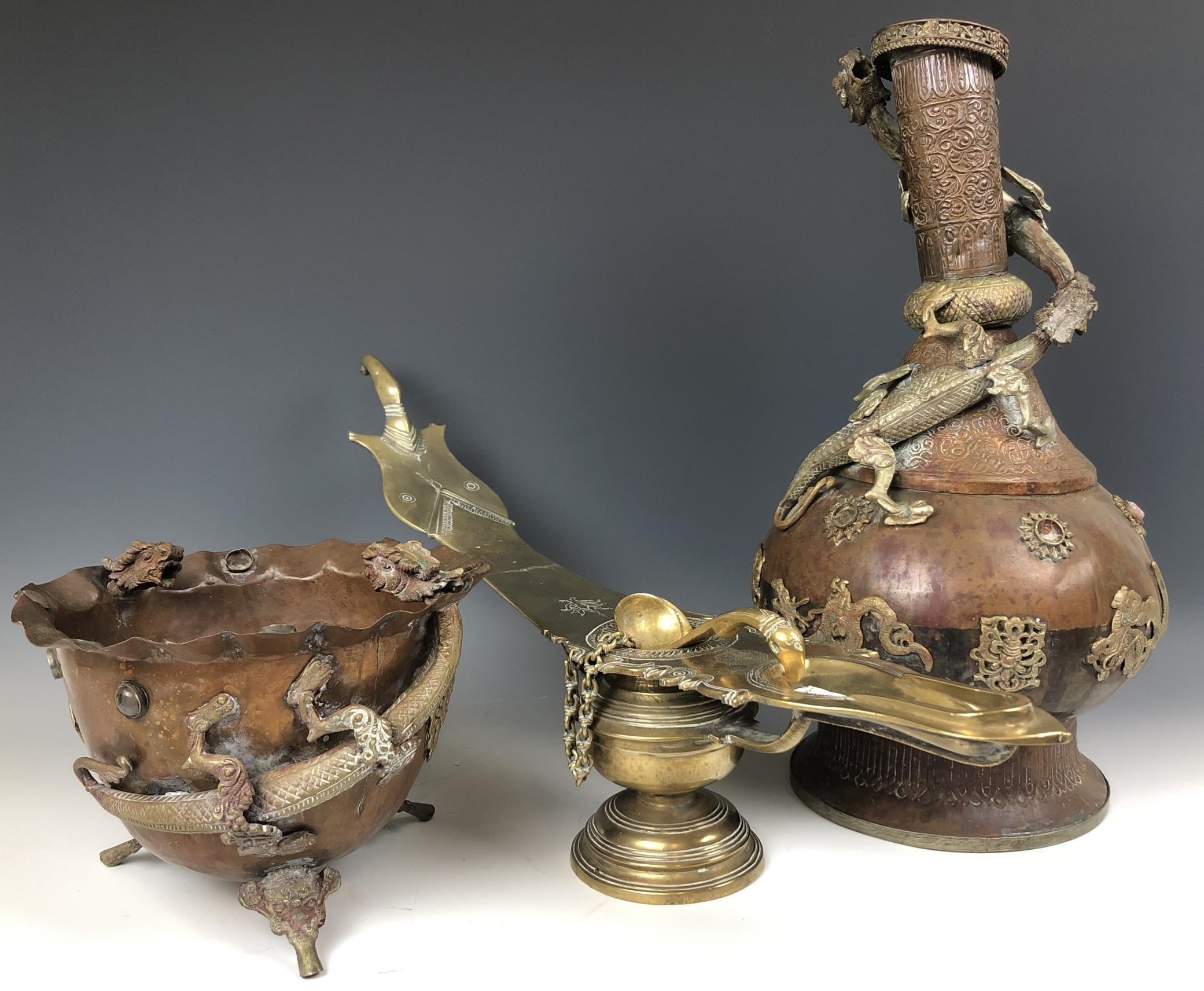 An Eastern brass oil lamp, 60 cm wide, and a brass and copper vase, decorated dragons, 49 cm high