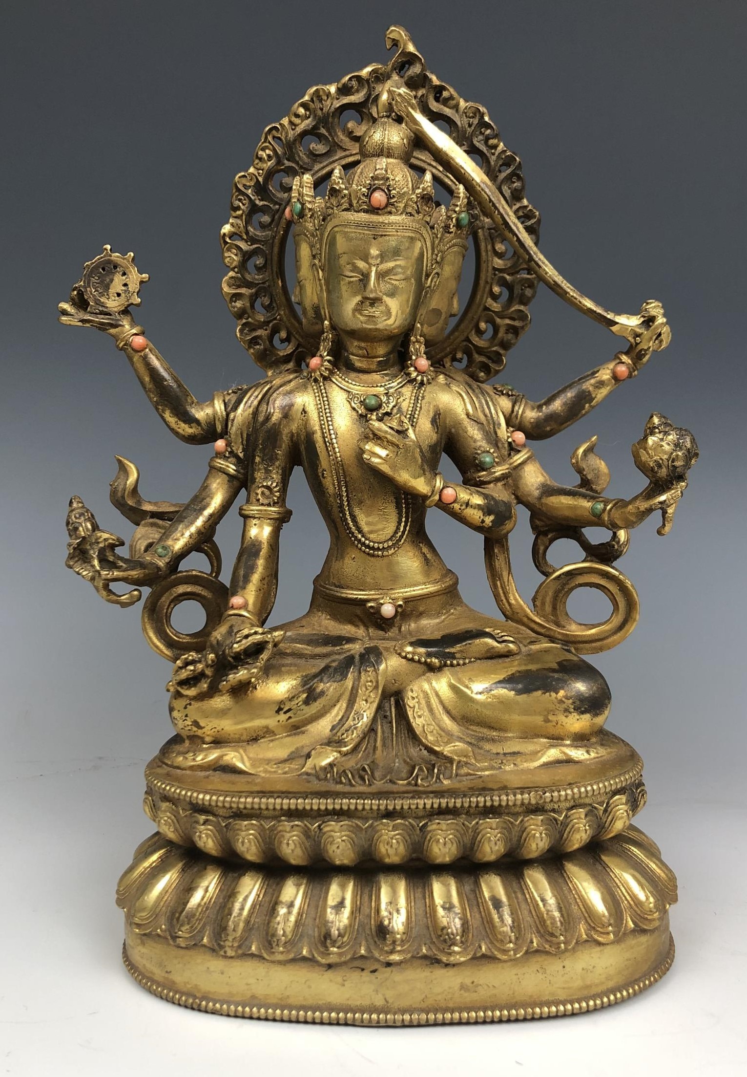 An Indian deity figure, set with green and peach stones, 25 cm high